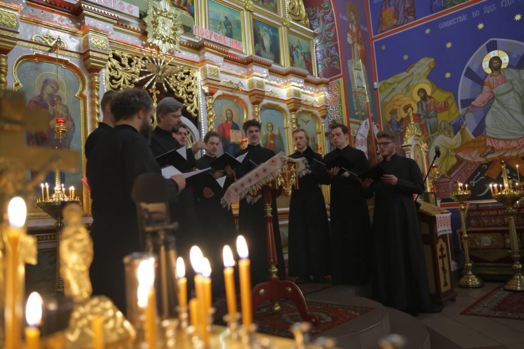 Zespół „Katapetasma” śpiewa w cerkwi, w tle widoczne złocone ikony.